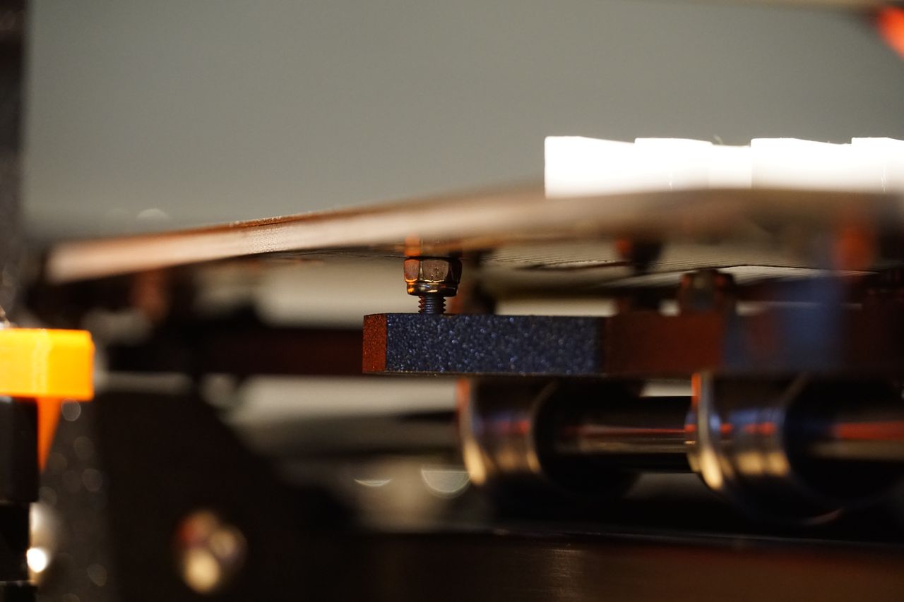 Schraube mit Mutter hält das Heizbett statt eine Abstandshülse.